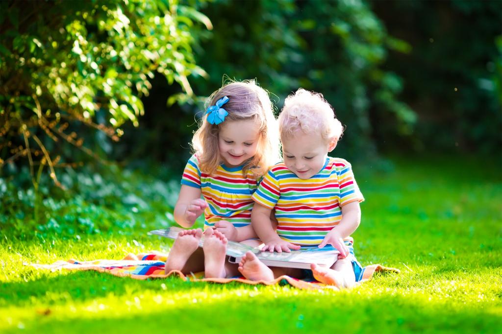 坐在绿草的小男孩和女孩阅读书
