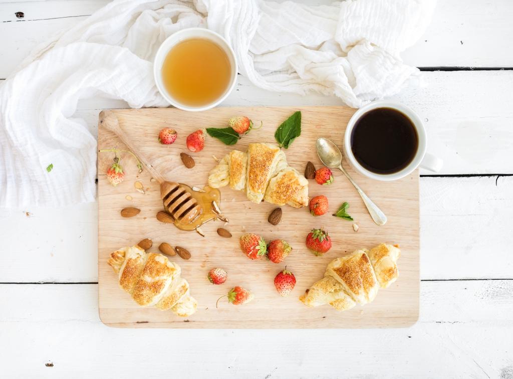 羊角面包，蜂蜜，新鲜的草莓和咖啡的早餐